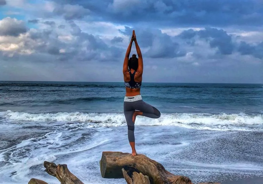 female doing yoga by the sea in bali