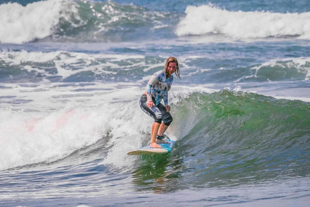 Woman standing on a surfboard riding Balinese waves
