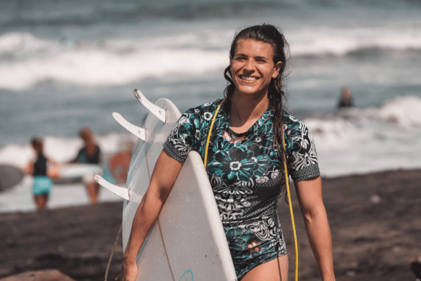 Girl walking on the beach with surfboard