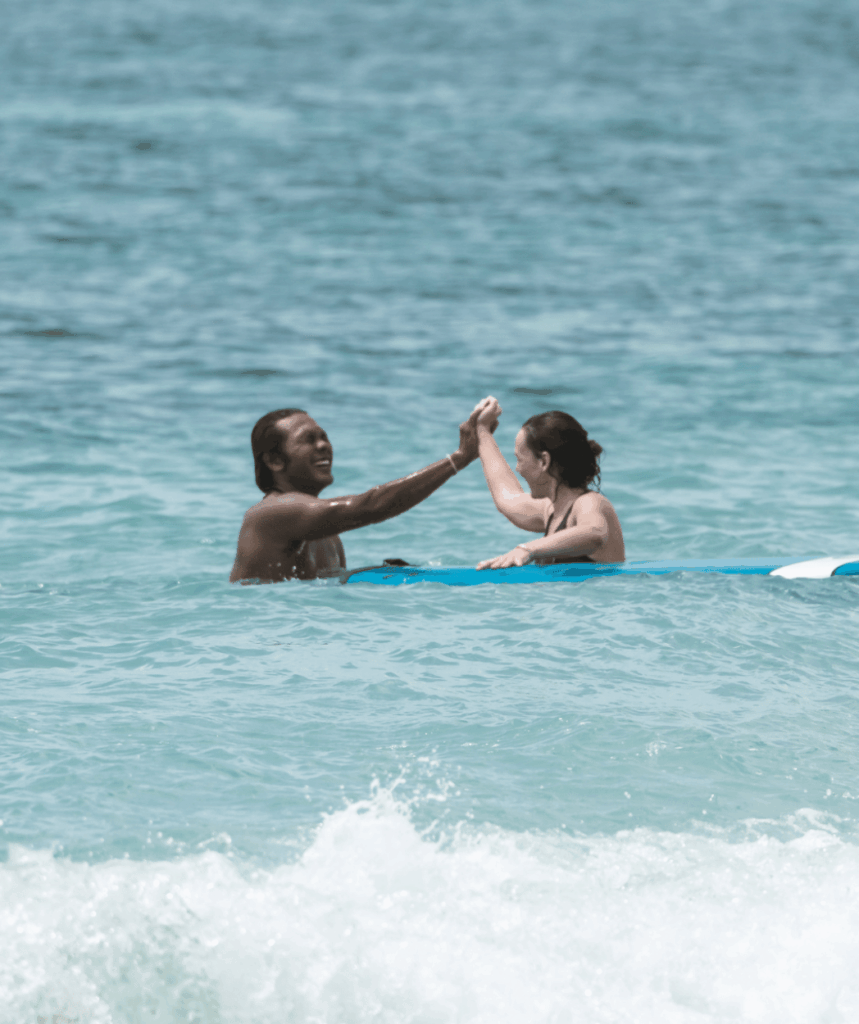 Teacher and student in the water surfing
