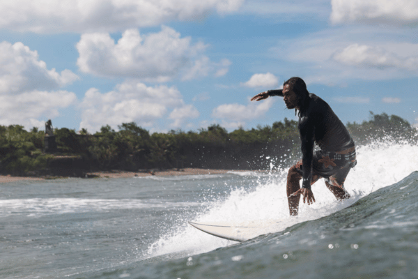 Guy surfing a wave in Canggu Bali