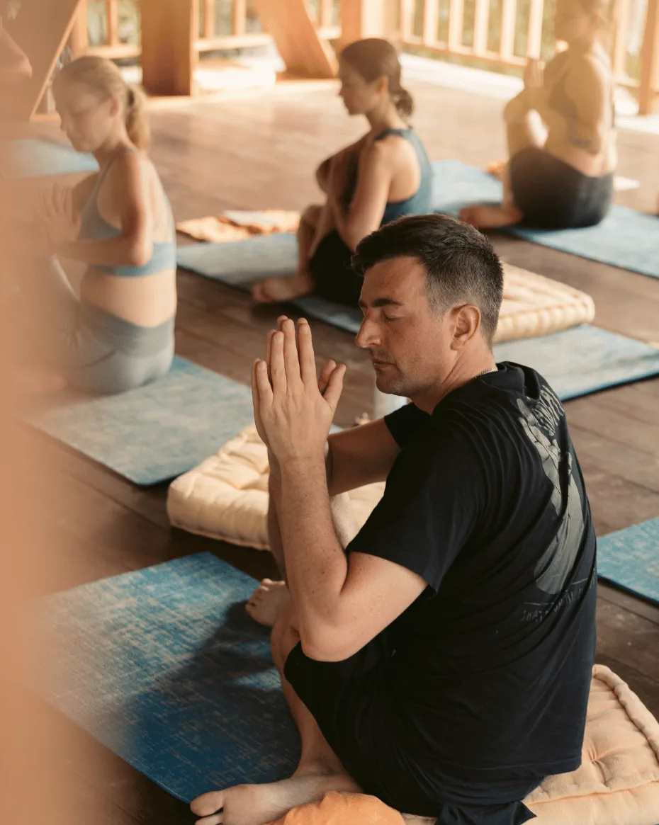 Hatha Yoga - zoomed in picture of a guy sitting on the floor practicing yoga