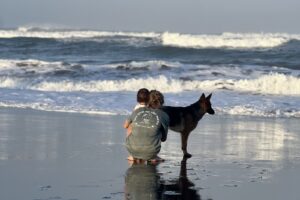 Mother and daughter enjoying the beach with a dog at our family surf camp in Bali