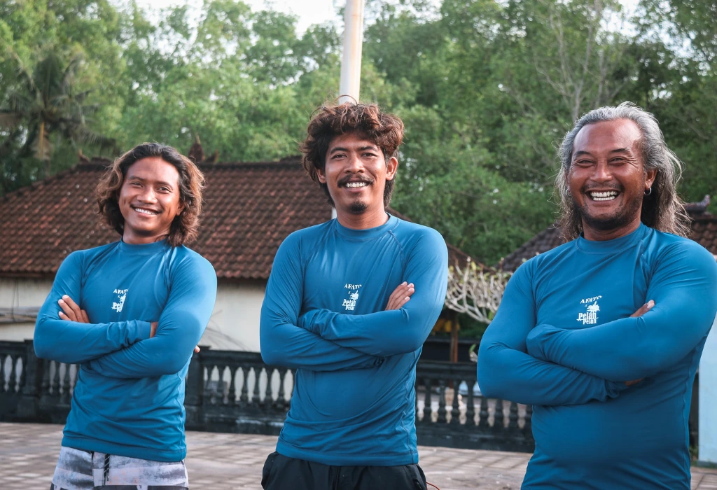 Three Surf instructors posing for a picture next to each others with their arm crossed